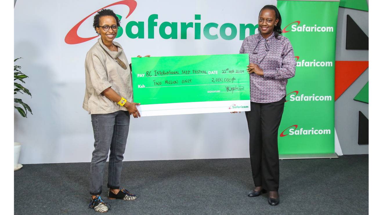 Wambui Kamiru and Safaricom official holding the dummy cheque. PHOTO/COURTESY